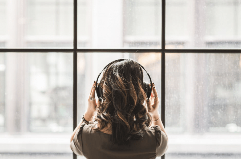 Woman in headphones in front of a large window