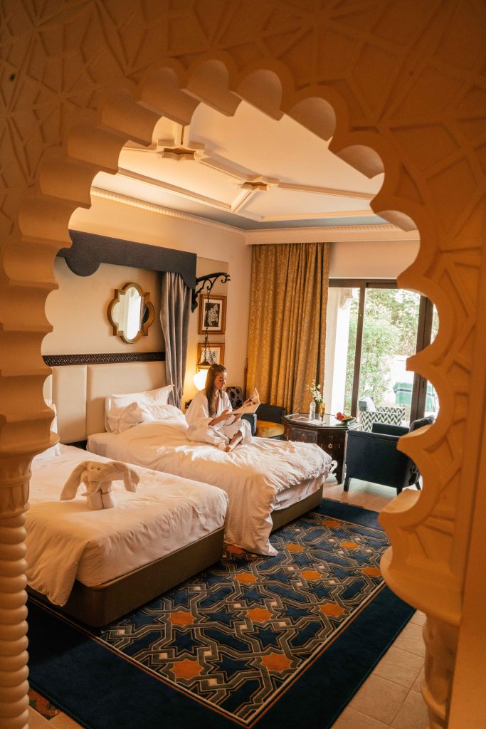 Arabian style room at Jumeirah Al Qasr Dubai with girl reading a magazine on the bed