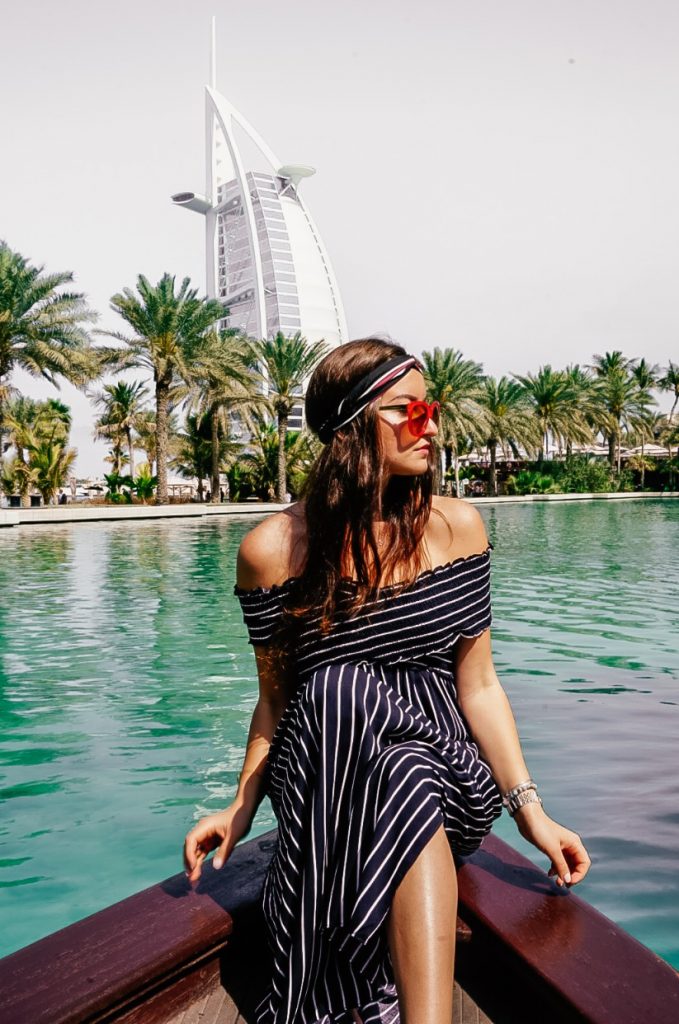 Elona the Explorer riding an abra in a striped dress with the Burj Al Arab in the background