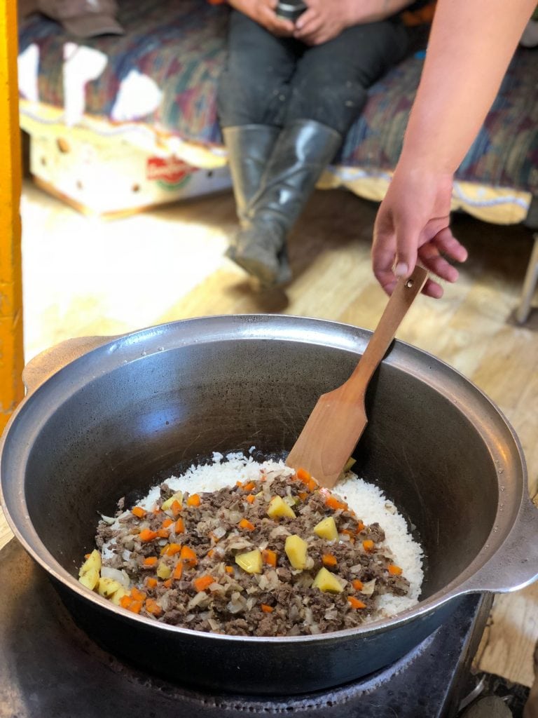 Cooking traditional Mongolian meal rice with beef and vegetables 