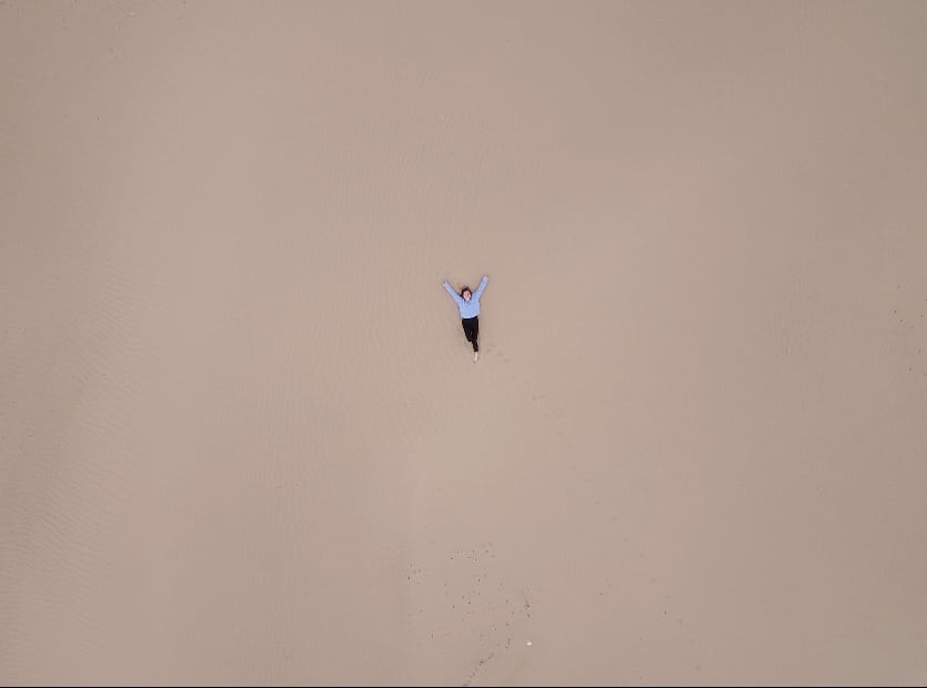 Girl laying in the sand of "mini Gobi" desert in Mongolia