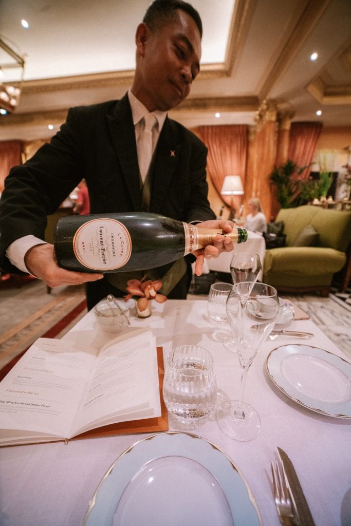 Waiter pouring champagne at The Dorchester Hotel London